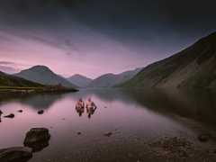 Two men sitting in Wast Water to cool their muscles after climbing Scafell Pike